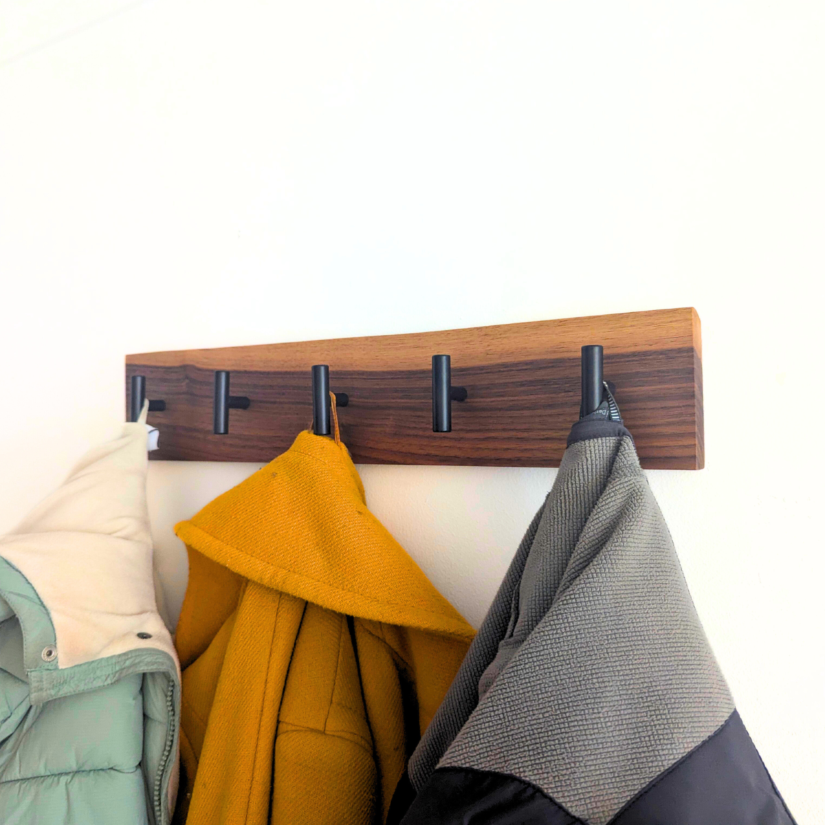 Modern Solid Black Walnut Coat Rack with Customizable Hooks - angled view with coats