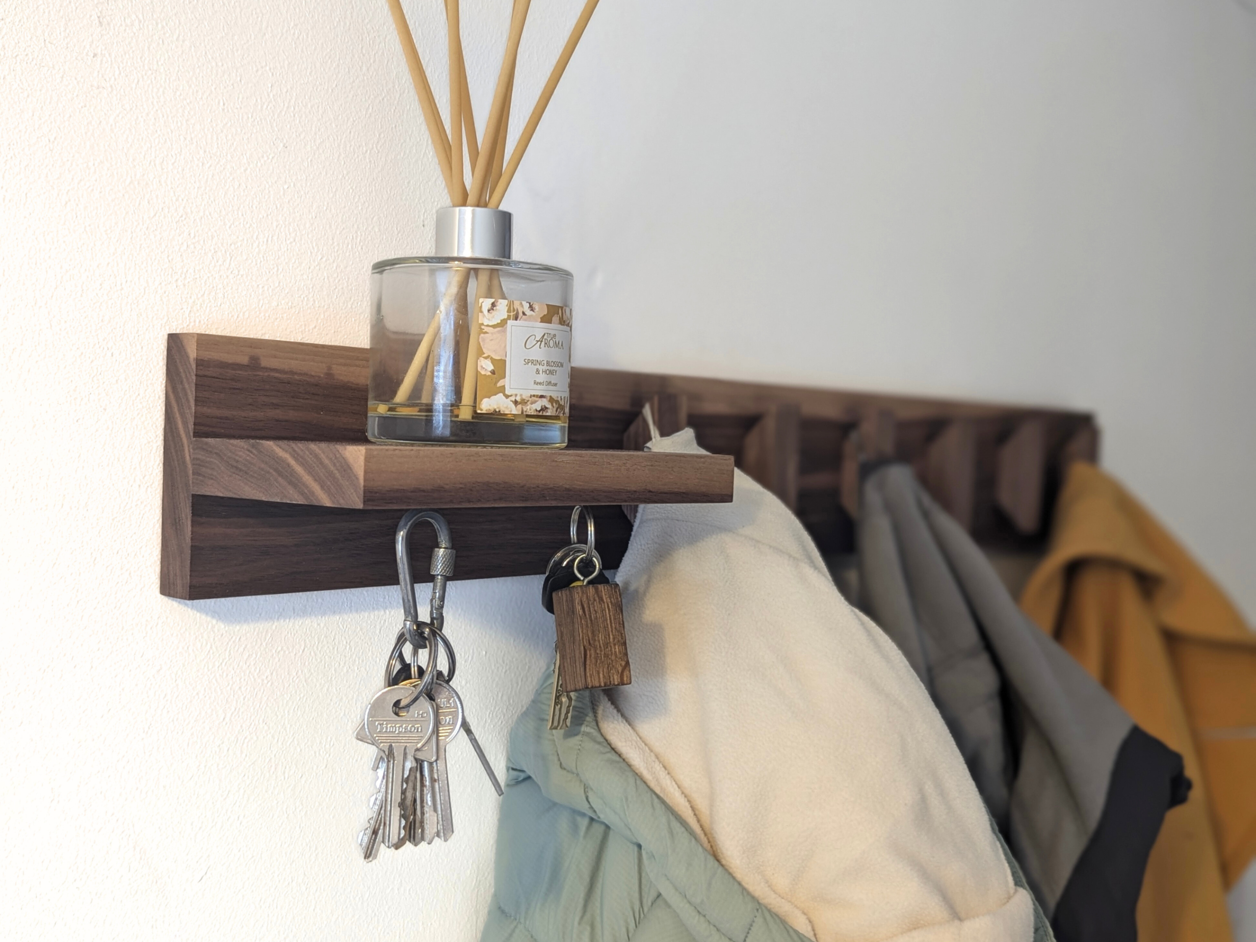 Solid Black Walnut Coat Rack With Shelf & Key Holders - angled view with coats