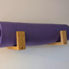 Solid Oak yoga mat hooks - wall mounted close together with mat overhanging, angled view