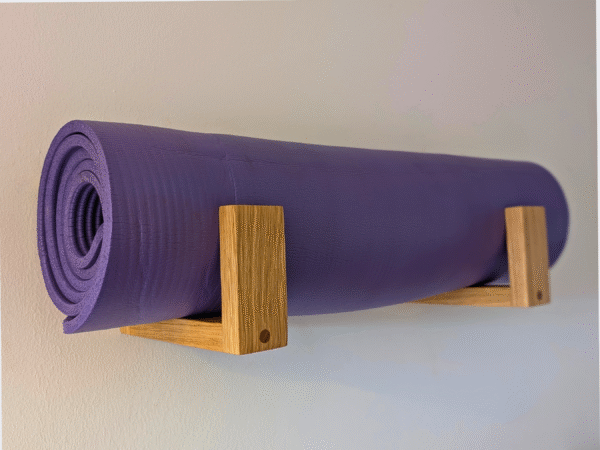 Solid Oak yoga mat hooks - wall mounted close together with mat overhanging, angled view