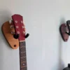 Solid Oak Plectrum Guitar Mount - angled image with guitars