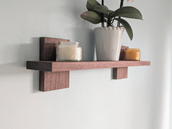 Modern Solid Black Walnut Scandi Floating Shelf - angled image with candles and orchid