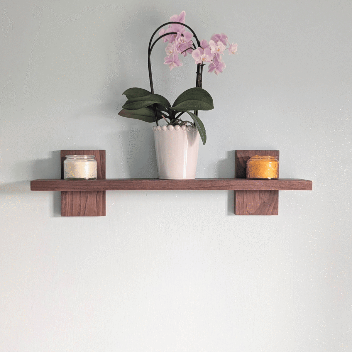 Modern Solid Black Walnut Scandi Floating Shelf - Straight image with candles and orchid