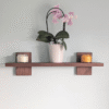 Modern Solid Black Walnut Scandi Floating Shelf - Straight image with candles and orchid